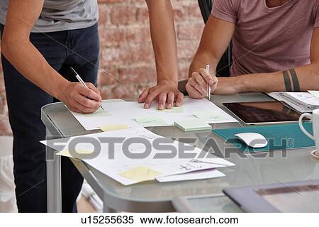 Two male colleagues, one making notes View Large Photo Image Stock Photography - Two male colleagues, one making notes. Fotosearch