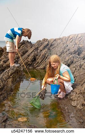 Two teenagers rock pooling View Large Photo Image Stock Photograph - Two teenagers rock pooling. Fotosearch