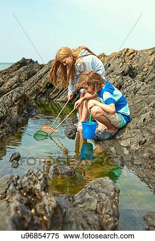 Two teenagers rock pooling View Large Photo Image Stock Photography - Two teenagers rock pooling. Fotosearch