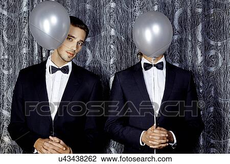 Two young men hiding behind balloons View Large Photo Image Stock Image - Two young men hiding behind balloons. Fotosearch