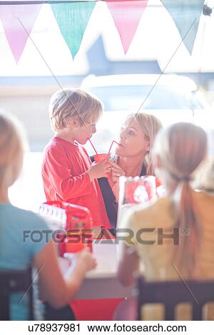 Two young sisters behind stall selling drink to mother View Large Photo Image Stock Image - Two young sisters behind stall selling drink to mother. Fotosearch