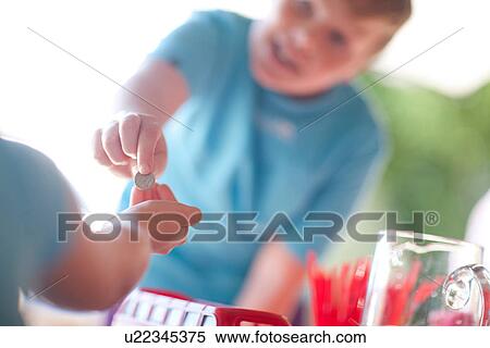 Two young sisters behind stall selling drink to cousin View Large Photo Image Stock Photography - Two young sisters behind stall selling drink to cousin. Fotosearch