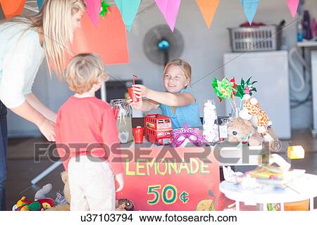 Two young sisters selling drink to mother from stall View Large Photo Image Picture - Two young sisters selling drink to mother from stall. Fotosearch