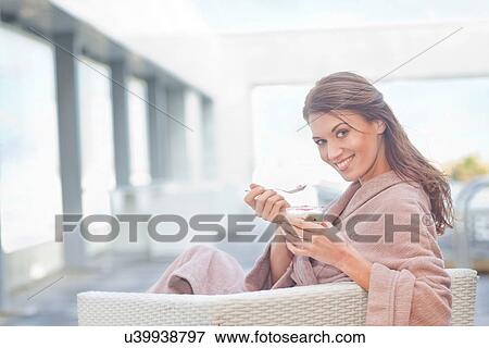 Stock Photo - Woman at hotel poolside eating yogurt. Fotosearch