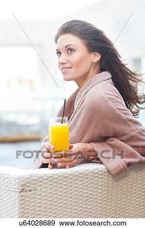 Woman at hotel poolside with orange juice View Large Photo Image Stock Photo - Woman at hotel poolside with orange juice. Fotosearch