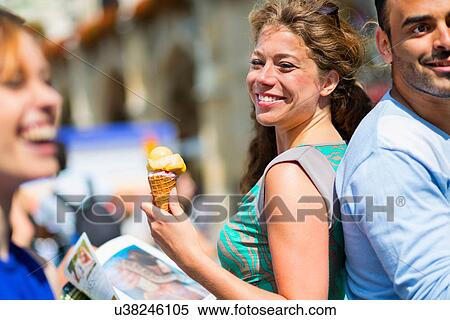 Stock Photography - Woman eating ice cream, smiling. Fotosearch