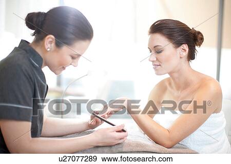 Stock Photo - Woman having her nails done in spa treatment room. Fotosearch