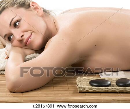 Stock Image - Woman having hot stone therapy. Fotosearch