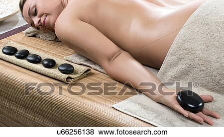 Stock Photo - Woman having hot stone therapy. Fotosearch
