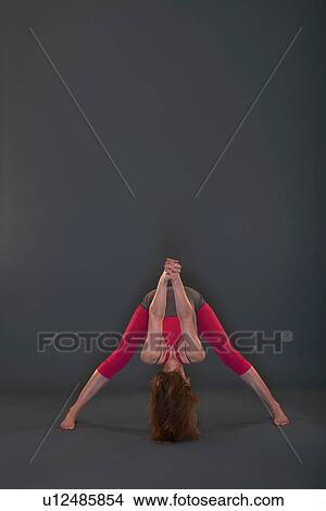 Picture - Woman in yoga pose on grey background. Fotosearch