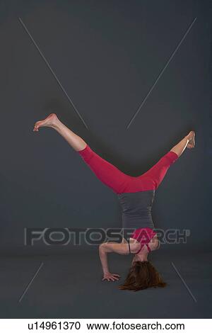 Stock Image - Woman in yoga pose on grey background. Fotosearch