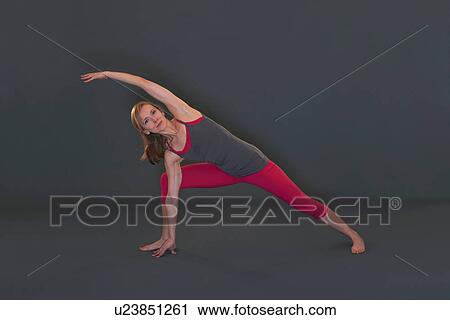 Stock Image - Woman in yoga pose on grey background. Fotosearch