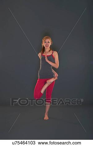 Stock Image - Woman in yoga pose on grey background. Fotosearch