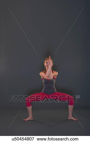 Stock Photo - Woman in yoga pose on grey background. Fotosearch