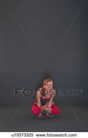 Stock Photography - Woman in yoga pose on grey background. Fotosearch