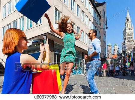 Woman jumping with shopping bag in Munich Marienplatz, Munich, Germany View Large Photo Image Stock Photo - Woman jumping with shopping bag in Munich Marienplatz, Munich, Germany. Fotosearch