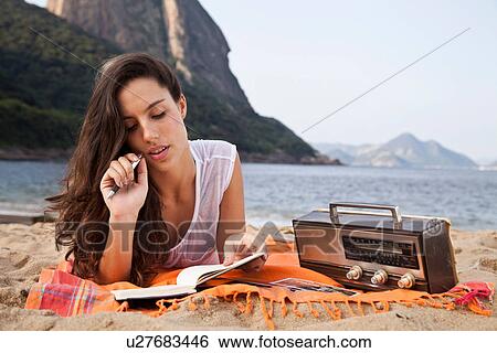 Woman on beach writing in notebook, Rio de Janeiro, Brazil View Large Photo Image Stock Photograph - Woman on beach writing in notebook, Rio de Janeiro, Brazil. Fotosearch