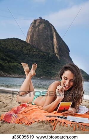 Woman on beach writing postcard, Rio de Janeiro, Brazil View Large Photo Image Stock Photo - Woman on beach writing postcard, Rio de Janeiro, Brazil. Fotosearch