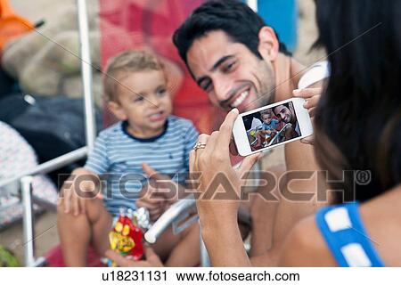 Woman photographing father and son, close up View Large Photo Image Stock Image - Woman photographing father and son, close up. Fotosearch