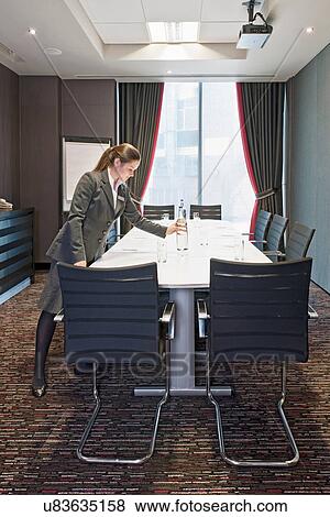 Woman preparing conference table View Large Photo Image Stock Photo - Woman preparing conference table. Fotosearch