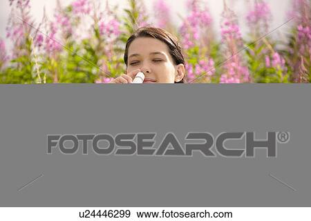 Stock Photo - Woman using allergy relief nasal spray. Fotosearch