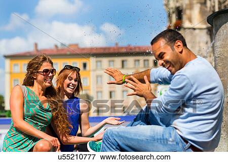 Stock Photo - Women splashing man with water. Fotosearch