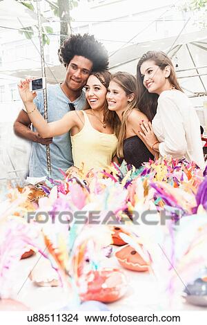 Young adults photographing themselves in market View Large Photo Image Picture - Young adults photographing themselves in market. Fotosearch