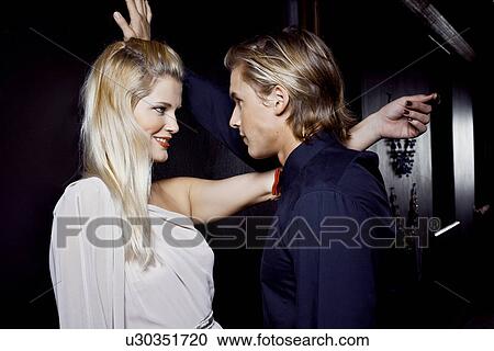 Young couple flirting in club View Large Photo Image Stock Image - Young couple flirting in club. Fotosearch