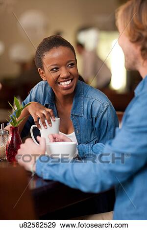 Young couple in cafe having coffee View Large Photo Image Stock Photo - Young couple in cafe having coffee. Fotosearch