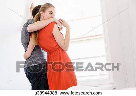 Stock Photo - Young couple in front of window. Fotosearch