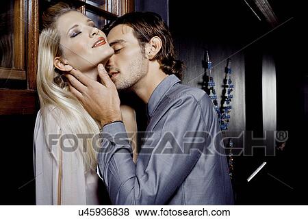 Stock Photo - Young couple kissing in nightclub. Fotosearch
