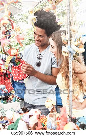 Stock Photograph - Young couple looking at souvenirs in market. Fotosearch