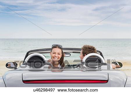 Young couple sitting in convertible sports car View Large Photo Image Stock Photo - Young couple sitting in convertible sports car. Fotosearch