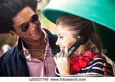 Young couple using pay telephone View Large Photo Image Stock Photo - Young couple using pay telephone. Fotosearch