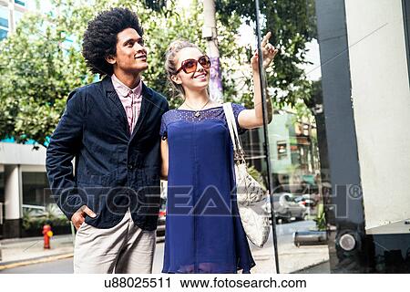 Stock Image - Young couple window shopping. Fotosearch