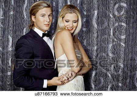 Stock Image - Young glamorous couple holding hands. Fotosearch