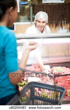 Young male sales assistant serving female customer View Large Photo Image Stock Image - Young male sales assistant serving female customer. Fotosearch