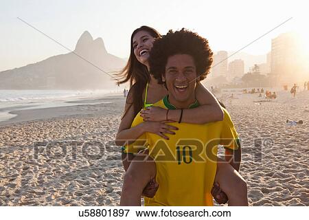 Young man giving girlfriend a piggyback, Ipanema Beach, Rio, Brazil View Large Photo Image Stock Photo - Young man giving girlfriend a piggyback, Ipanema Beach, Rio, Brazil. Fotosearch