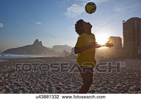 Young man heading football, Ipanema Beach, Rio, Brazil View Large Photo Image Stock Image - Young man heading football, Ipanema Beach, Rio, Brazil. Fotosearch
