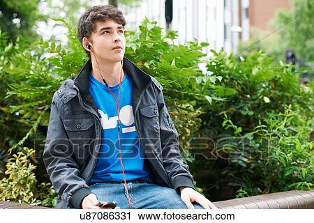 Young man wearing earphones View Large Photo Image Stock Image - Young man wearing earphones. Fotosearch