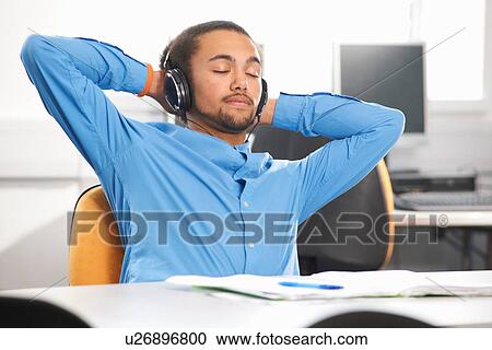 Stock Image - Young man wearing headphones. Fotosearch