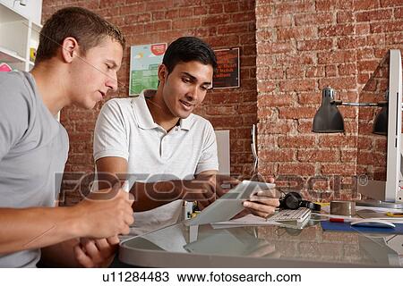 Young men using digital tablet View Large Photo Image Stock Image - Young men using digital tablet. Fotosearch