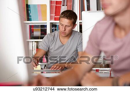 Young men working, focus on background View Large Photo Image Picture - Young men working, focus on background. Fotosearch