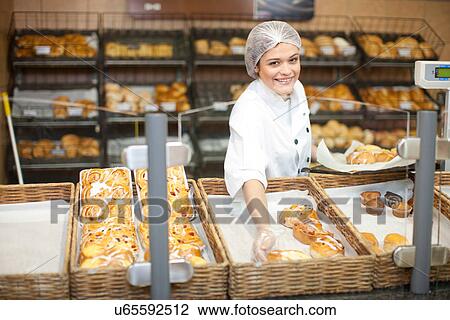 Young sales assistant holding sweet pastries View Large Photo Image Stock Image - Young sales assistant holding sweet pastries. Fotosearch