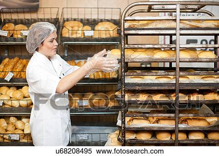 Young sales assistant with trays of bread View Large Photo Image Stock Photography - Young sales assistant with trays of bread. Fotosearch