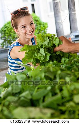 Young woman buying fresh leaves in market View Large Photo Image Stock Photo - Young woman buying fresh leaves in market. Fotosearch