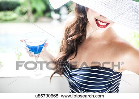 Young woman holding blue cocktail View Large Photo Image Stock Photography - Young woman holding blue cocktail. Fotosearch