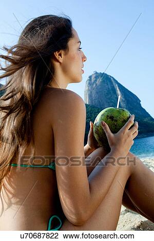 Young woman holding coconut drink, Rio de Janeiro, Brazil View Large Photo Image Stock Image - Young woman holding coconut drink, Rio de Janeiro, Brazil. Fotosearch