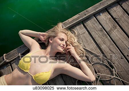 Young woman lying on pier View Large Photo Image Stock Photography - Young woman lying on pier. Fotosearch