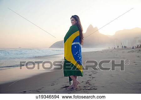 Young woman on beach, wrapped in Brazilian Flag View Large Photo Image Picture - Young woman on beach, wrapped in Brazilian Flag. Fotosearch